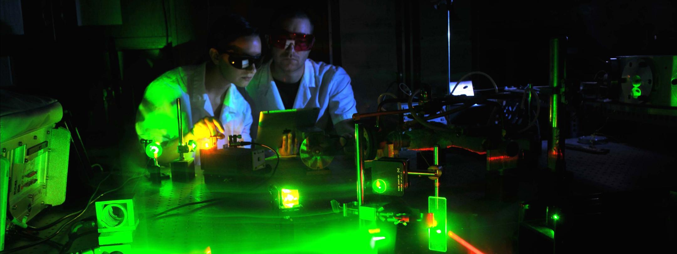 Physics student working with lasers in a laboratory setting.